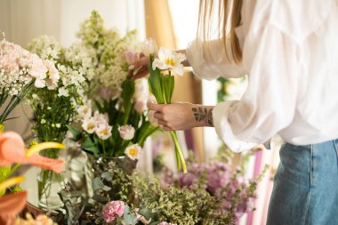 İşteki çiçekçi: farklı çiçeklerden modern buket yapan kadın. Yüksek kalite fotoğraf