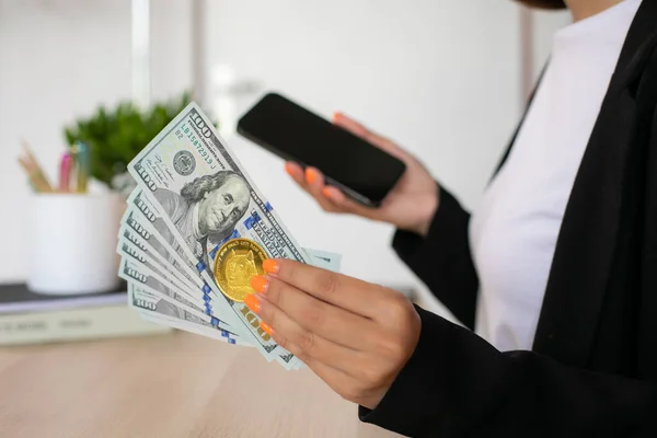 İş yerindeki kadınların ellerinde dolar banknotları ve dogecoin. Yüksek kalite fotoğraf