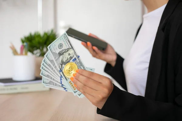 İş yerinde elinde telefon olan kadınlara dolar ve kripto para. Yüksek kalite fotoğraf