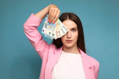 Avro banknotlarını yüzüne yakın tutan genç bir kadın. Yüksek kalite fotoğraf