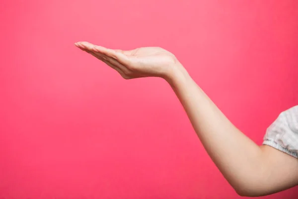Boş kadın eli pembe arka planda izole edilmiş bir şeyi tutuyormuş gibi yapıyor. Yüksek kalite fotoğraf