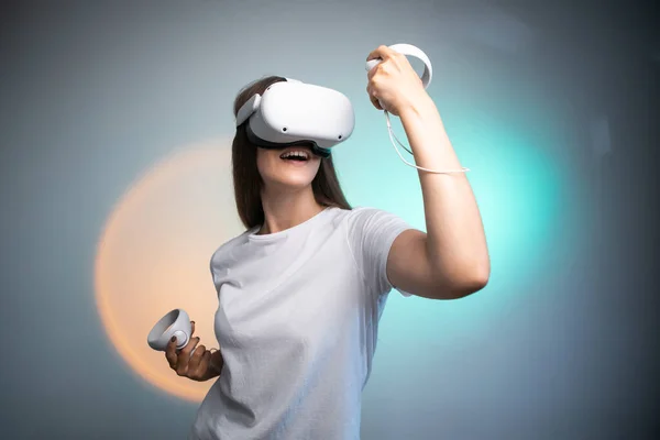 Portrait of young womans playing in VR-glasses colorful background. Concept of human emotions, facial expression, modern gadgets and technologies. Look like winner. High quality photo