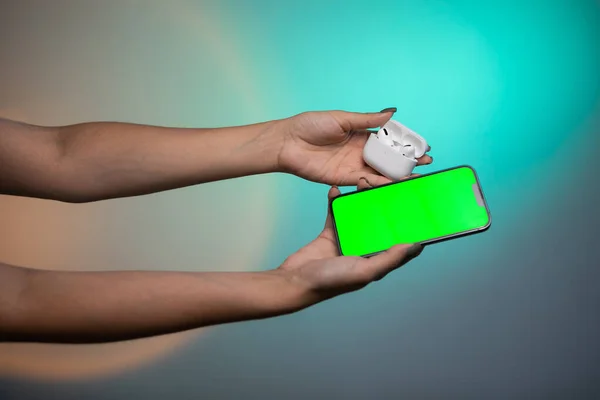 Modern wireless headphone and gadget with green screen. . High quality photo