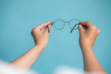 Female hand with stylish glasses on colorful background. High quality photo