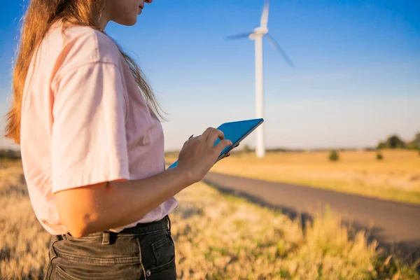 girl watching windmills and watching at tablets. High quality photo