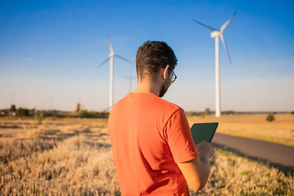 men watching windmills and watching at tablets. High quality photo