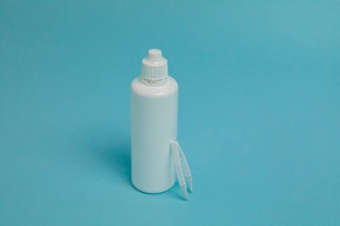 tweezers and drops for lenses on blue background. High quality photo