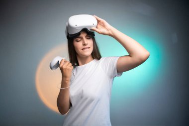 Portrait of young womans playing in VR-glasses colorful background. Concept of human emotions, facial expression, modern gadgets and technologies. Look like winner. High quality photo