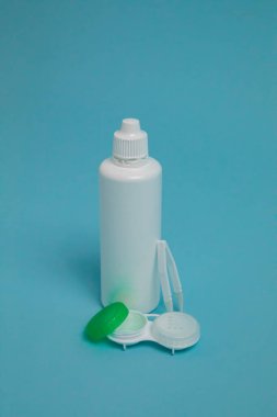 Packages with contact lenses, case, tweezers and drops on blue background. High quality photo