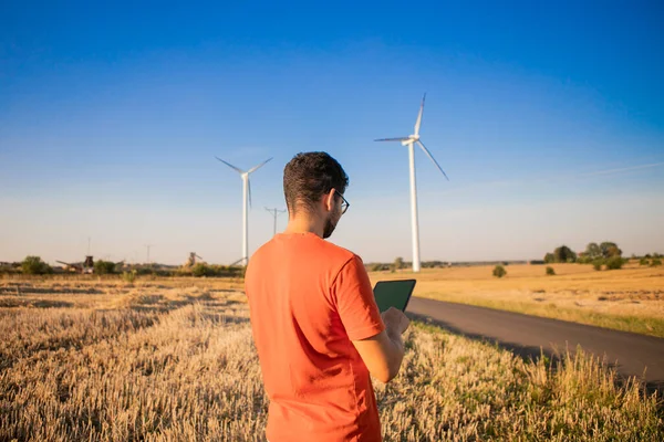 men watching windmills and watching at tablets. High quality photo