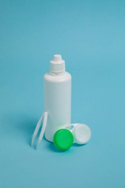 Packages with contact lenses, case, tweezers and drops on blue background. High quality photo