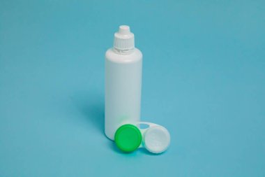 Packages with contact lenses, case and drops on blue background. High quality photo