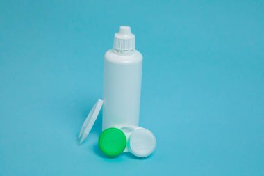 Packages with contact lenses, case, tweezers and drops on blue background. High quality photo