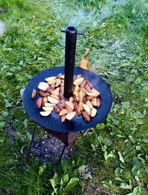 Kızarmış patates, domuz pastırması ve soğanlı, dökme demir tavada.