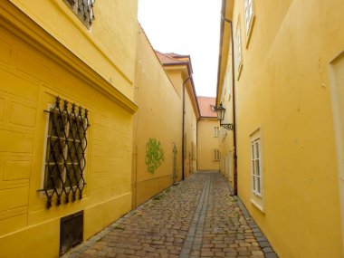 Prague Alley in the Old City, Praha Narrow Street with old cobblestone and yellow buildings, Alleyway Medieval Street, Jewish Quarter, Czech Republic