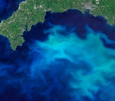 Blooms of phytoplankton in the sea around England, aerial top view photo of blue sea from clear sky, turquoise ocean image background, selective focus. Elements of this image furnished by NASA.