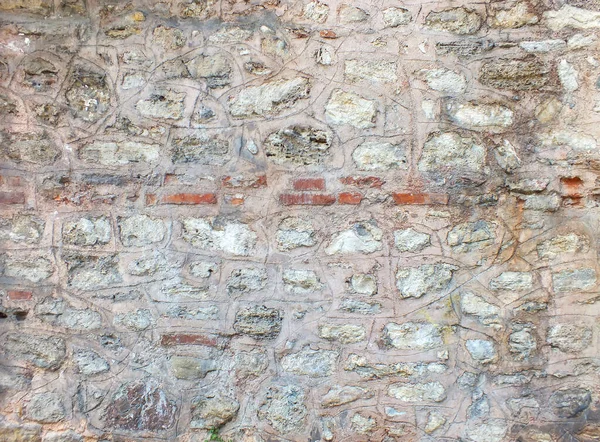 Old medieval stone wall sandy color texture background for design with copy space. Selective focus. Noise and grain included.