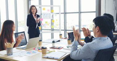 Bir grup iş adamı konferans odasında toplanıyor. Asyalı iş adamı konuşması, mevcut takım çalışması ortaklığı. Mutlu iş adamları toplantı odasında grafik çizelgesi yatırımı ve iş verilerini karşılıyorlar.