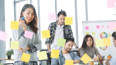 Çeşitli etnik gruplar, iş ortağıyla toplantı yapan ve konferans odasında fikirlerini paylaşan beyin fırtınası yapan gruplar. Yaratıcı tasarım meslektaşı strateji planı yapışkan notlar kullan, sunum fikirleri