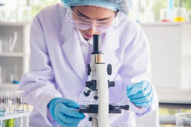 Laboratuvardaki kadın bilim adamı mikroskop tıbbi testine ve biyoloji kimyasına bakıyor. Bilimsel eczane genetik araştırmalarını analiz eden kadın teknisyen laboratuarı. Kimya Tıp Laboratuvarı