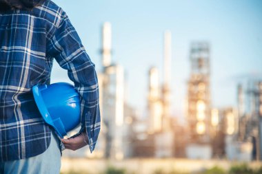 Elektrikçi, teknik operatör, mavi şapkalı, iş kaskı mühendisi. Mavi kasketi tutan mühendis kadın. Elektrikçi kadın işçi petrol endüstrisi güvenliği mavi işçi kaskında.