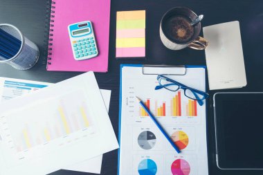 Ofis dizüstü bilgisayarının finansal döküman şeması ve kahve fincanı ile ahşap masanın üzerindeki grafiği. Düz dizüstü bilgisayar ofis masasında duruyordu. İş sahasında iş grafiği modellemesi yok