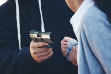 Hırsız silahlı bir adam sokakta kadını silahla soydu. Korkak Asyalı kadın tehlikeli haydut tarafından soyuldu. Hırsız silahlı soyguncu kullanıyor. Saldırganlık suçu kavramı.