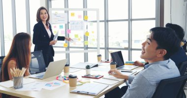 Bir grup iş adamı konferans odasında toplanıyor. Asyalı iş adamı konuşması, mevcut takım çalışması ortaklığı. Mutlu iş adamları toplantı odasında grafik çizelgesi yatırımı ve iş verilerini karşılıyorlar.