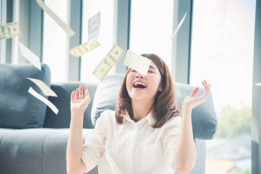 Elinde dolar olan mutlu Asyalı kadın mutluluğu kutluyor zenginliği kutluyor piyango parası yağmur damlası. Kazanan iş kadını para akışı yapar gülen surat