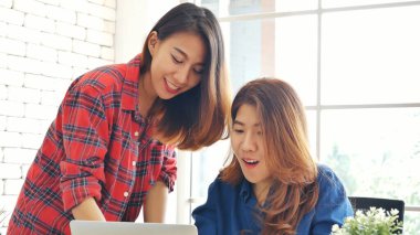 Ofis masasında kendine güvenen iki kadının birlikte çalışması mutluluktur. Bilgisayar şirketi ile çalışan takım ortakları. Asyalı iş arkadaşı arkadaşlığı gülen yüzle iş başında.