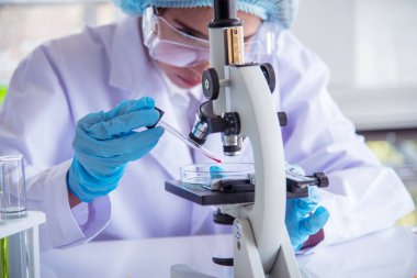 Kapalı alan kadın bilim adamı laboratuvarda düşürücü kullanıyor. Bilimsel mikroskop tıbbi testi, biyoloji kimyası araştırması. Kadın teknisyen laboratuarı kan bilimsel ilaç araştırmalarını inceliyor..