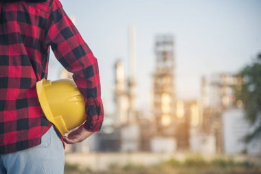 Kadın işçi elleri sarı kasklı inşaat mühendisi. Rafineri kadın petrol endüstrisi sarı işçi miğferini tutuyor. Rafineri endüstrisi mühendisi üretimi