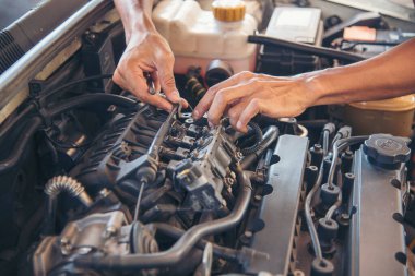 Otomobil makinelerinin mekanik servisini tamir eden elleri kapatın. Tamirci araba tamirhanesini tamir ederken ellerini kaldırdı. Araç kaputu otomobili kontrol ediyor. Araç bakım mühendisi.