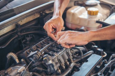 Tamirci araba tamirhanesini kapatırken araba tamircisini de eline aldı. Makineli araç mekanik servisini tamir eden adam elleri. Araç kaputu otomobili kontrol ediyor. Araç bakım mühendisi.