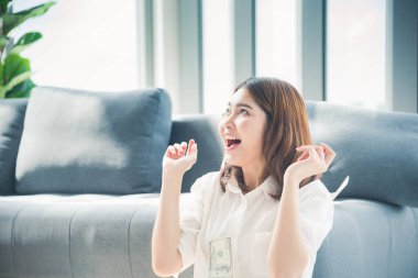 Elinde dolar olan mutlu Asyalı kadın mutluluğu kutluyor zenginliği kutluyor piyango parası yağmur damlası. Kazanan iş kadını para akışı yapar gülen surat