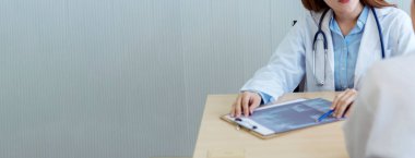 Banner Two Asyalı kadın doktorlar klinikle görüşmeyi tartıştılar. Genç Asyalı kadın doktor, röntgen filminde hastalara birlikte danışmanlık yapıyor. Kopya alanı olan Panorama Asya tıbbi bakım laboratuvarı