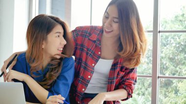 Ofis masasında kendine güvenen iki kadının birlikte çalışması mutluluktur. Bilgisayar şirketi ile çalışan takım ortakları. Asyalı iş arkadaşı arkadaşlığı gülen yüzle iş başında.