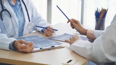 İki Asyalı kadın doktor, doktorun muayenehanesinde röntgen filmi danışmanlığı yapan hastalarla görüşmeyi tartışıyor. Asya tıp laboratuarındaki genç kadınlar birlikte sağlık hizmetleri hakkında konuşuyorlar.