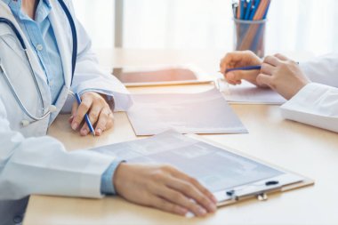 İki Asyalı kadın doktor, doktorun muayenehanesinde röntgen filmi danışmanlığı yapan hastalarla görüşmeyi tartışıyor. Asya tıp laboratuarındaki genç kadınlar birlikte sağlık hizmetleri hakkında konuşuyorlar.