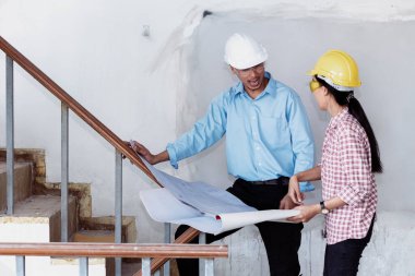 İnşaat mühendisi takım çalışması güvenlik ekibi, inşaat sahasında beyaz sarı şapkalı güvenlik ekipmanı tutuyor. Hardhat İnşaat Mühendisliği Mühendisliği Yöneticisini Koru