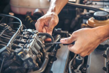 Tamirci araba tamirhanesini kapatırken araba tamircisini de eline aldı. Makineli araç mekanik servisini tamir eden adam elleri. Araç kaputu otomobili kontrol ediyor. Araç bakım mühendisi.