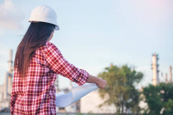 İnşaat mühendisi kadın işçi sanayisinde ekose gömlekli, beyaz kasketli, inşaat işçisi. Mimari mühendis kadın memur emlak projesine bakıyor.