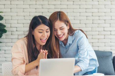 Ofis masasında kendine güvenen iki kadının birlikte çalışması mutluluktur. Bilgisayar şirketi ile çalışan takım ortakları. Asyalı iş arkadaşı arkadaşlığı gülen yüzle iş başında.