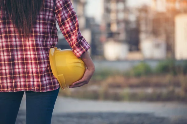 Refinery woman worker oil petro industry hand hold yellow worker helmet hard hat. Woman worker hands holding hardhat yellow work helmet Construction Engineer. Refinery industry engineer manufacture