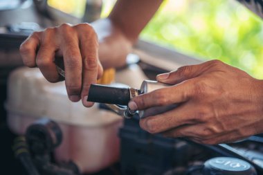 Tamirci araba tamirhanesini kapatırken araba tamircisini de eline aldı. Makineli araç mekanik servisini tamir eden adam elleri. Araç kaputu otomobili kontrol ediyor. Araç bakım mühendisi.