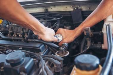 Otomobil makinelerinin mekanik servisini tamir eden elleri kapatın. Tamirci araba tamirhanesini tamir ederken ellerini kaldırdı. Araç kaputu otomobili kontrol ediyor. Araç bakım mühendisi.