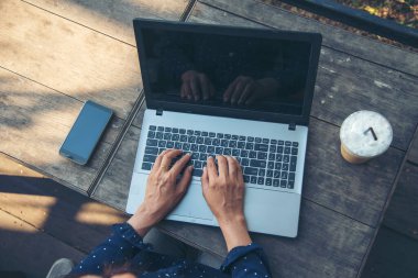 Kahve dükkanının bahçesinde dizüstü bilgisayar kullanarak kadın ellerini kapat. Üst görünüm, bilgisayar klavyesi boş ekranında çalışan serbest çalışan kadın. Boş Ekran Laptop Blogcusu Kadın elleri daktilo eden bilgisayar klavyesi