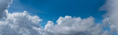 Banner Tropikal yaz mavi gökyüzü pofuduk beyaz bulut yaz mevsimi açık güneşli gün bulutları. Panoramik berrak mavi siluet ilkbahar güneş ışığı iklim arkaplanı. Web pankartı için cennet mavisi ekoloji