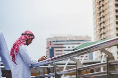 Akıllı telefon uygulaması kullanan İslami adam, ajandasını akıllı telefon Müslüman modern uae şehrine odaklıyor. Arap erkekleri tesettür ve Müslüman resmi giysileri giyer. Çevrimiçi yaşam tarzı mesajları gönderir.