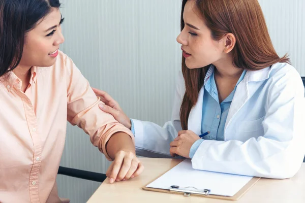 Woman doctor holding hands patient encourage cheer up consultation at hospital medicare treatment clinic. Doctor talking to patient support giving hope listening takecare for mental health therapy